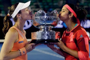 Martina Hingis, left, of Switzerland and Sania Mirza of India kiss their trophy after defeating Czech Republics Andrea Hlavackova and Lucie Hradecka in the women's doubles final at the Australian Open tennis championships in Melbourne, Australia, Friday, Jan. 29, 2016. (AP Photo/Aaron Favila)