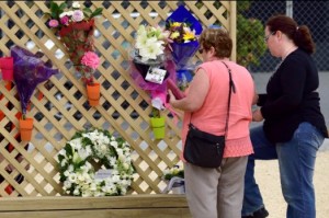 Family members of a woman died in 2011 earthquake placing flowers on a wooden wall in Christchurch, New Zealand on the fifth anniversary of the deadly quake.