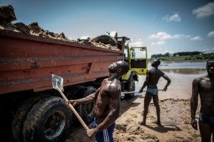 Sand diggers are seen loading trucks at a quarry on the banks of the Congo river in the  Kombe district of Brazzaville.-AFP