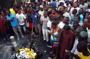 People of Haiti are looking at dead body of a person killed in a blast at a gas station in  Port- au-Prince.-AFP