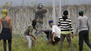 Migrants trying to remove barbed wires along the fence during a clash with Macedonian police at the northern Greek border point of Idomeni, Greece on Wednesday. 
