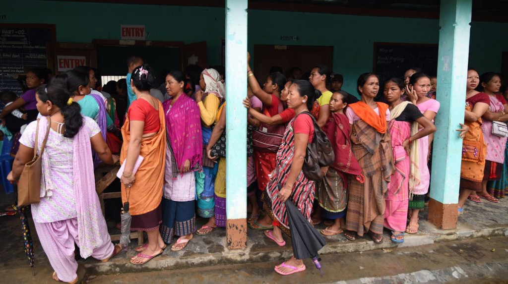 Indian women voters are standing in queue for casting votes at a polling station in the State Assembly  elections in Gawhati.-AFP