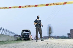 A Pakistani police commando stands alert at a cordon near a house on the outskirts of Lahore on June 29, 2015, following a raid on property allegedly used by Taliban militants. Pakistani police and counter terrorism forces raided a house near the eastern city of Lahore and killed four Taliban militants, officials said. AFP PHOTO / ARIF ALI / AFP / Arif Ali