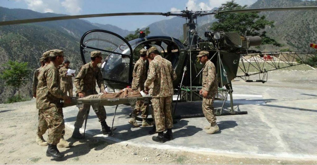 Pak soldiers shifting an injured person in Chitral floods to hospital on Sunday. - SABAH