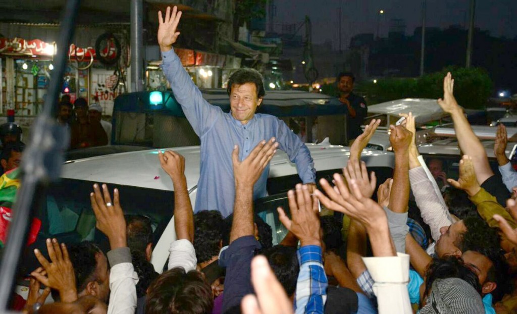 Chairman PTI Imran Khan replying to the slogans of workers by waving hand during his visit to Lahore. - NNI