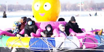 People enjoy ice-snow fun on an entertainment facility on the frozen  Songhua River in Harbin, northeast China’s Heilongjiang Province.