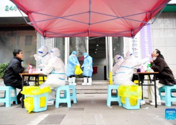Medical workers take swab samples from citizens for nucleic acid test  at a COVID-19 testing site in Zhengzhou, central China’s Henan Province