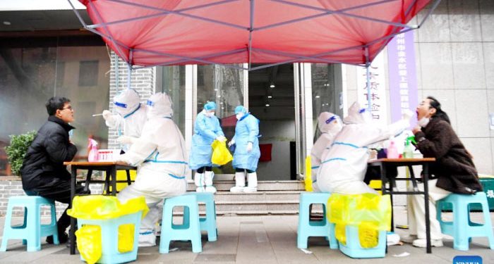 Medical workers take swab samples from citizens for nucleic acid test  at a COVID-19 testing site in Zhengzhou, central China’s Henan Province