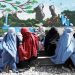 Afghan women wait to receive a food package